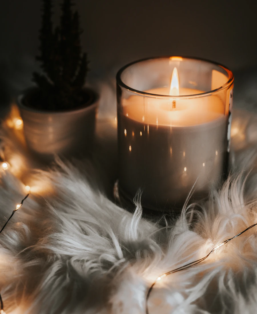 A lit candle in a glass jar